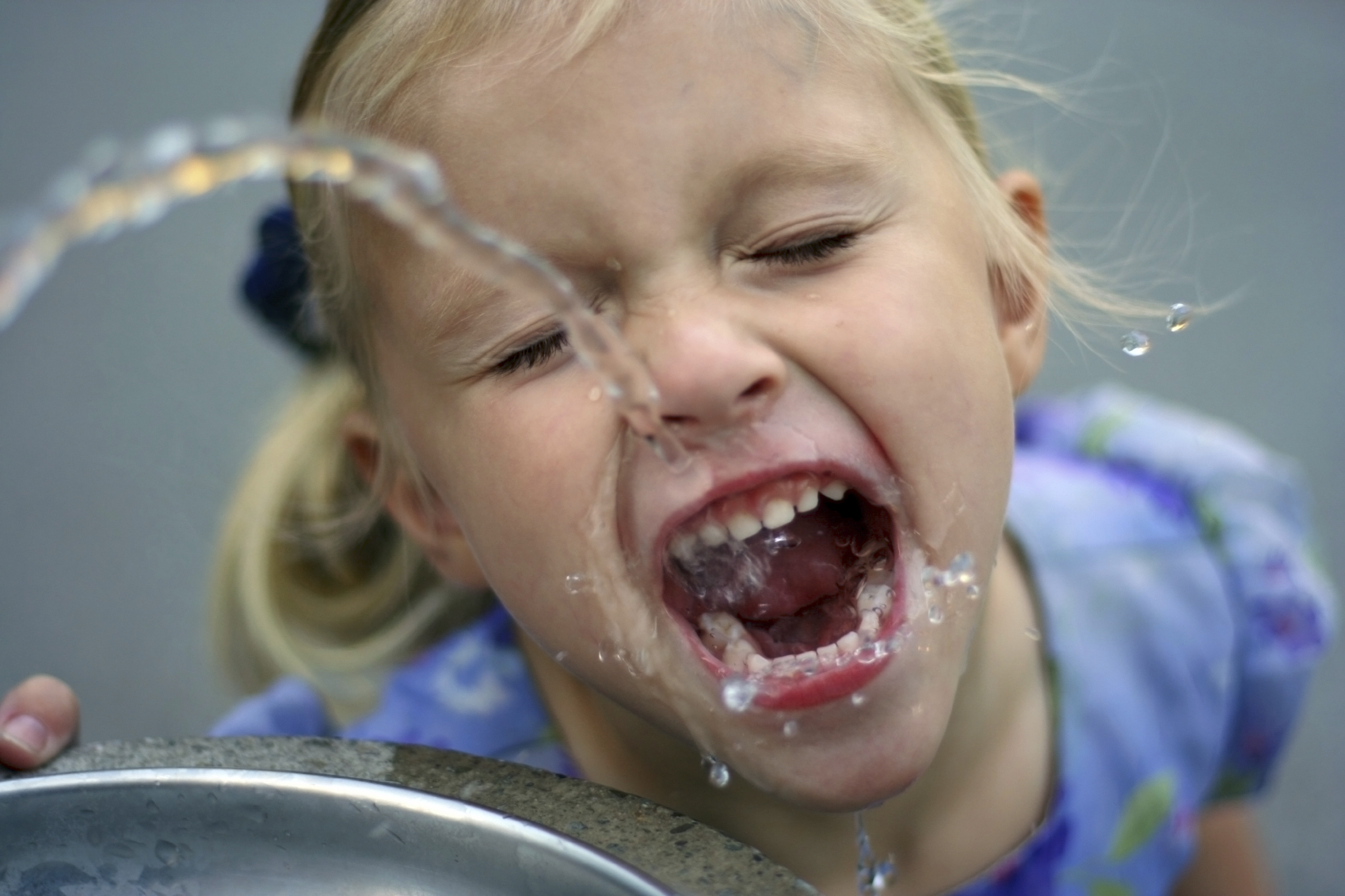 kid drinking water from fountain